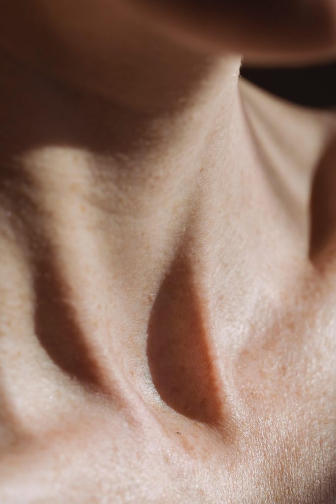 Close-up of a woman's neck showing natural skin texture and contours.